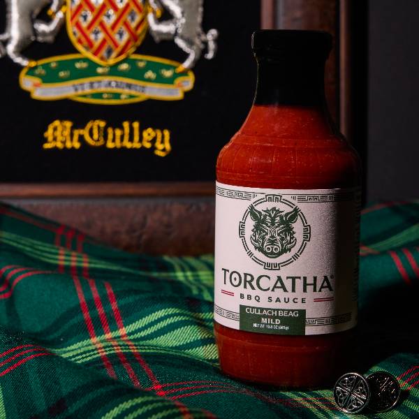 Bottle of Torcatha BBQ sauce on a plaid fabric with McCulley logo in the background