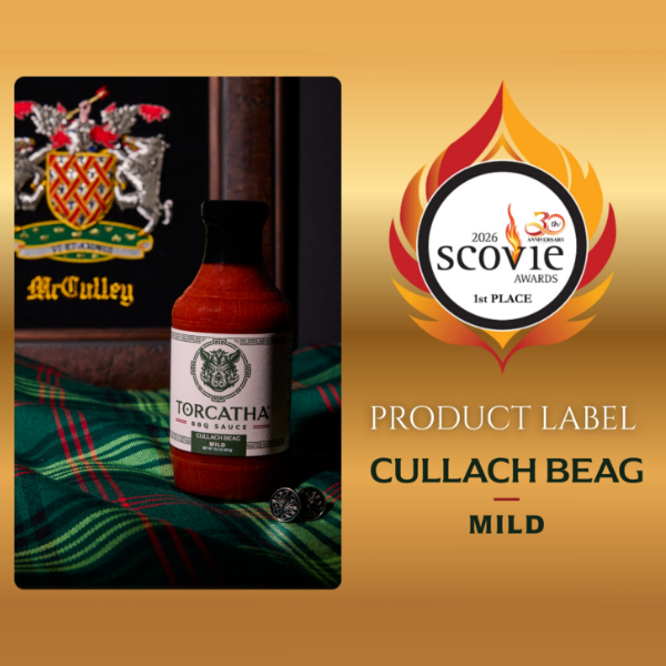 Image of the 2026 Scovie Award, 1st Place Product Label for Cullach Beag Mild BBQ Sauce, shown alongside a bottle of Torcatha BBQ Sauce on a Scottish plaid fabric, with the McCully family crest in the background. 